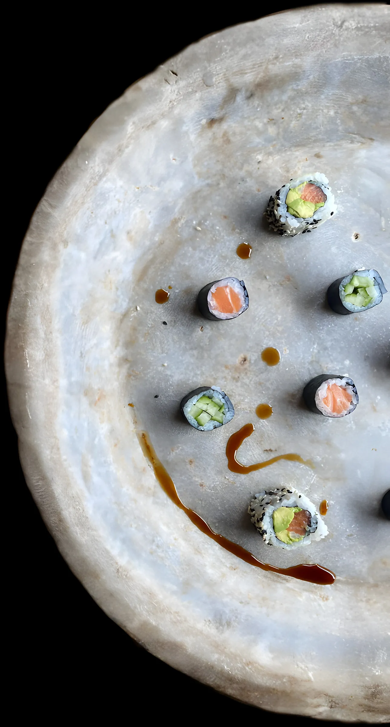 Hoso maki op een stenen bord met saus