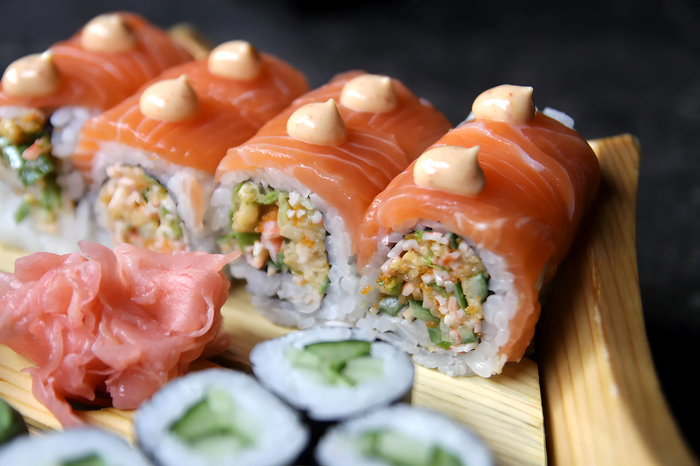 Rolls met zalm en saus op een houten plank
